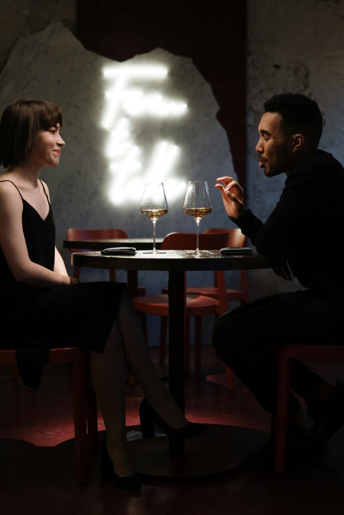 Couple enjoying a romantic evening with wine at a stylish cafe setting.